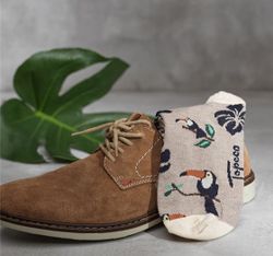 Tukan en herrstrumpa från Topeco. Färg: Beige botten med ett skönt mönster med tukaner i svart.