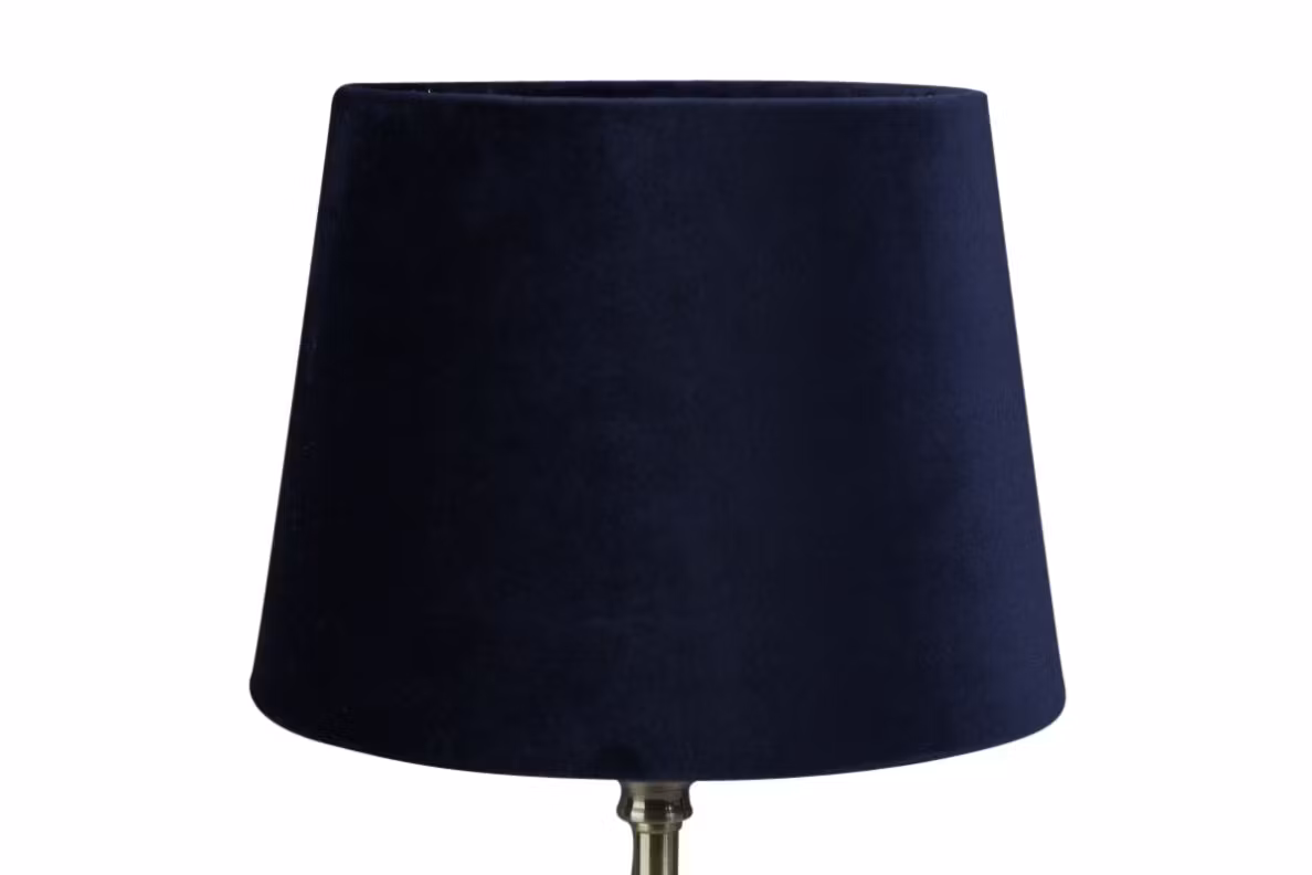 Sam en rund lampskärm i mörkblå sammet med fäste för både E14 och E27 lampor från Stjernsund kollektion.