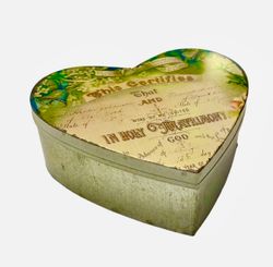 In holy en stor hjärtformad plåtburk med ett vackert tryck på locket från Svanefors, mått h 20 x b 21 x h 7 cm.