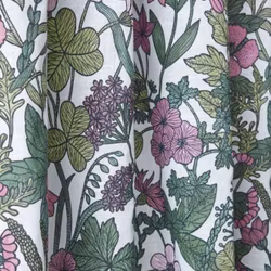 Malva en blommig metervara med rosa blommor och gröna blad på en vit botten från Svanefors i bredd 145 cm