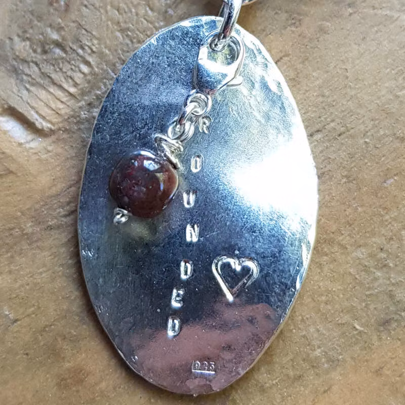 Mala Grounded mörk sandelträ, närbild silverhänge med text