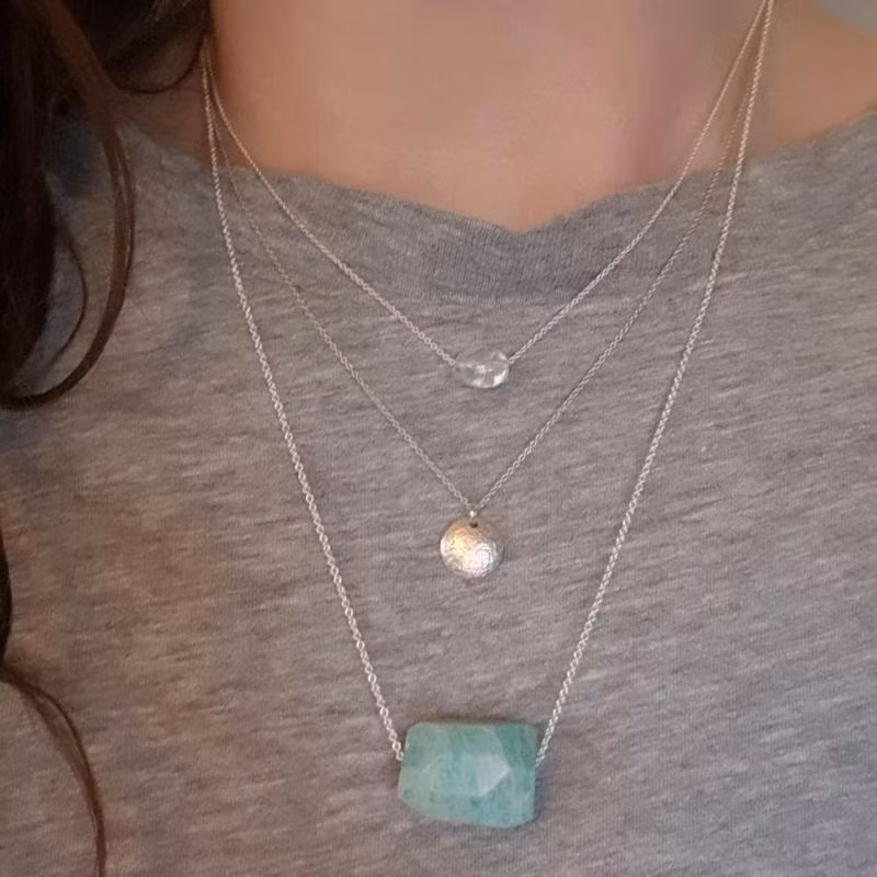 Silverhalsband Spirit Stone Amazonit tillsammans med silverhalsband La Luna grace & Tiny pebbles bergkristall på person.