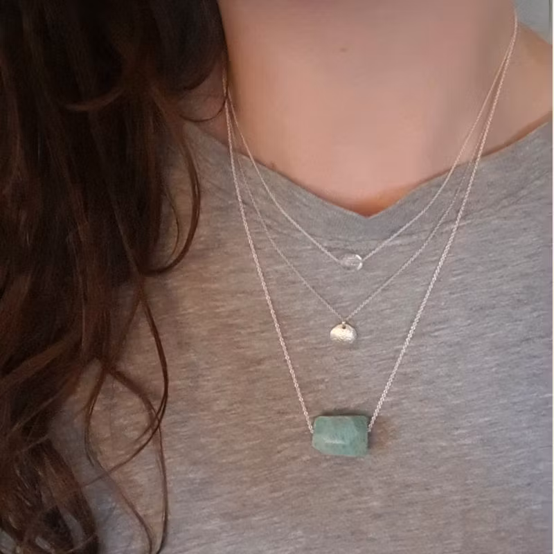 Silverhalsband Spirit Stone Amazonit tillsammans med silverhalsband La Luna grace & Tiny pebbles bergkristall på person.