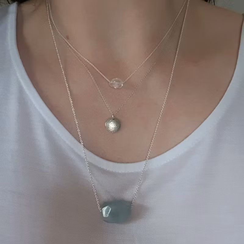 Silverhalsband Spirit Stone Akvamarin tillsammans med silverhalsband La Luna grace & Tiny pebbles bergkristall på person