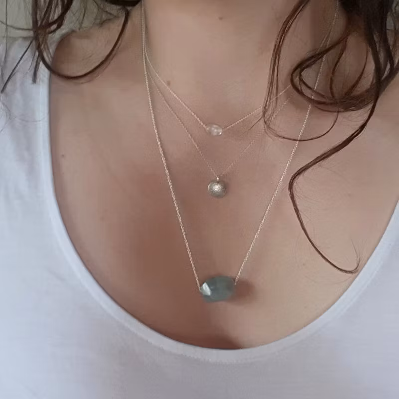 Silverhalsband Spirit Stone Akvamarin tillsammans med silverhalsband La Luna grace & Tiny pebbles bergkristall på person.