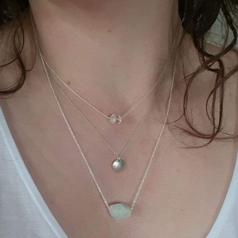 Silverhalsband Spirit Stone Akvamarin mini tillsammans med silverhalsband La Luna grace & Tiny pebbles bergkristall på person.