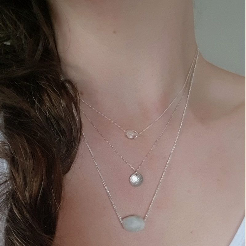 Silverhalsband Spirit Stone Akvamarin mini tillsammans med silverhalsband La Luna grace & Tiny pebbles bergkristall på person.