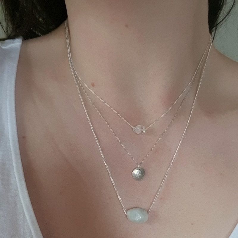Silverhalsband Spirit Stone Akvamarin mini tillsammans med silverhalsband La Luna grace & Tiny pebbles bergkristall på preson.
