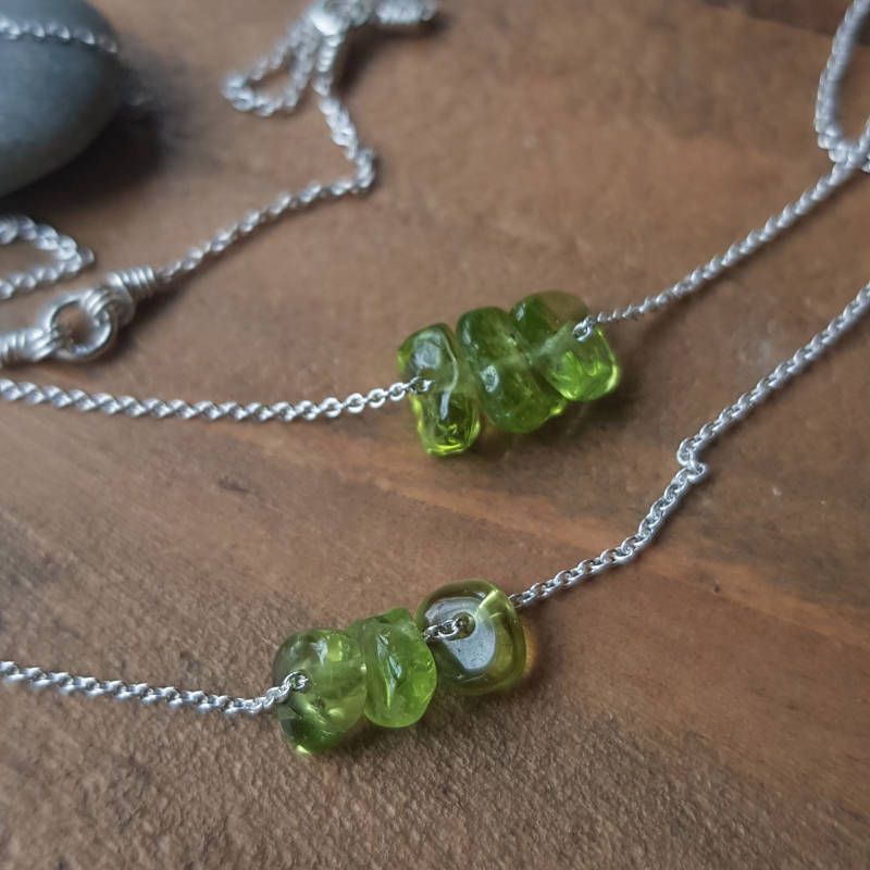 Två exempel på silverhalsband med peridot, månadssten för augusti. Stenarna varierar i nyans, form & uttryck.