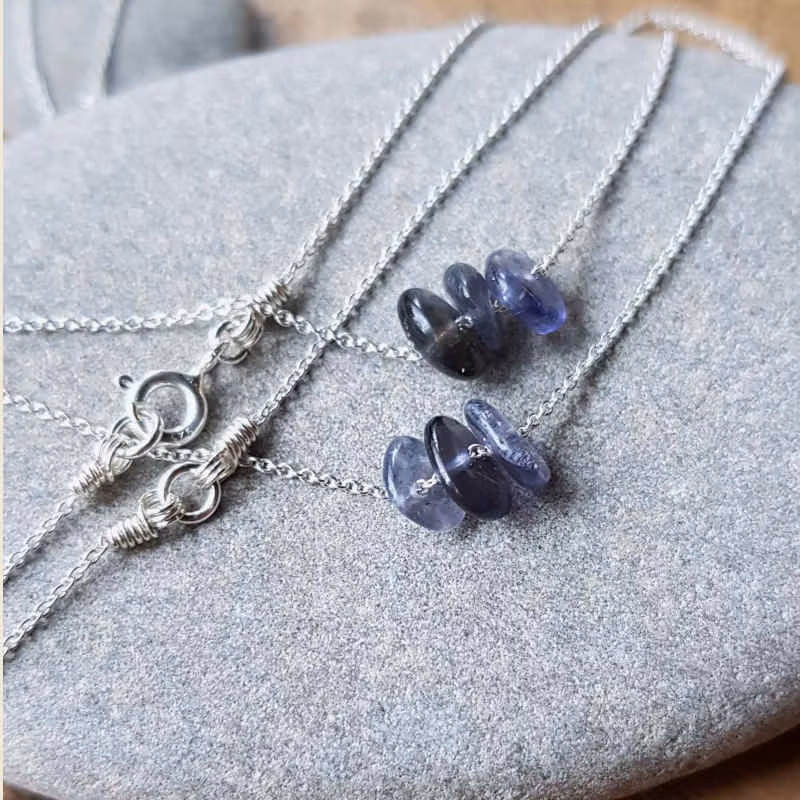 Två exempel på silverhalsband med iloit, månadssten för september. Stenarna skiftar naturligt i nyans, form & uttryck.