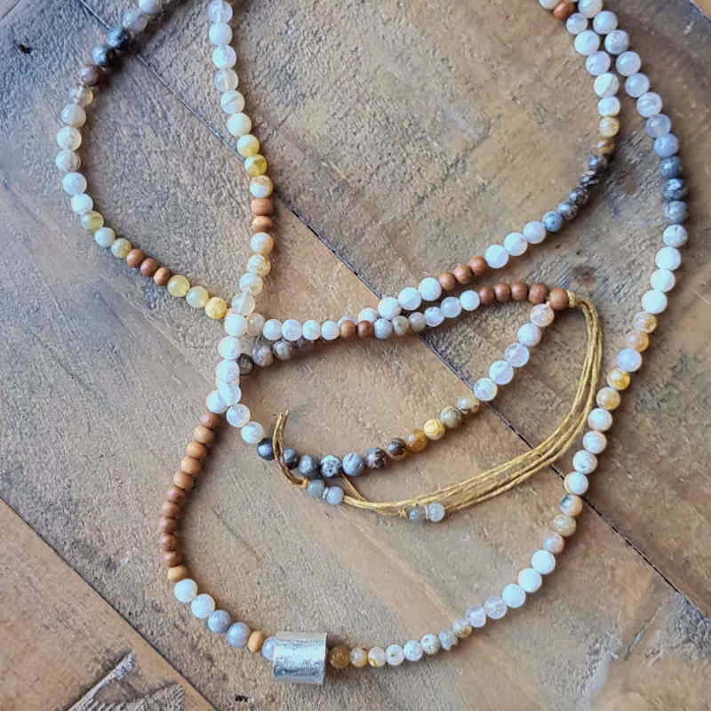 Långt halsband i jordnära nyanser med en harmonisk känsla.