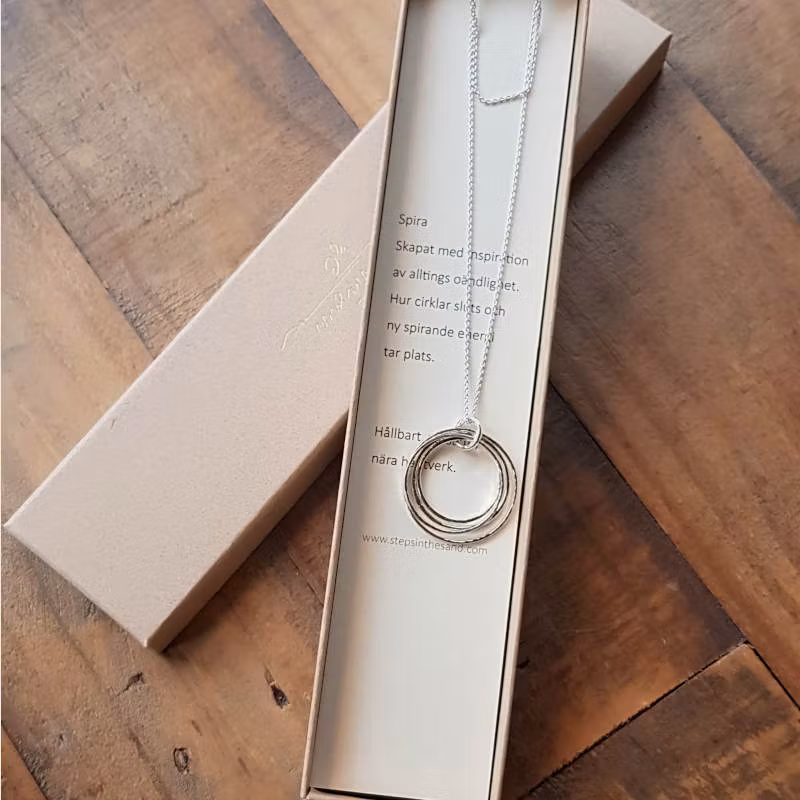 Halsbandet skickas i fin smyckeask med ett kort där källan till inspiration står skriven.