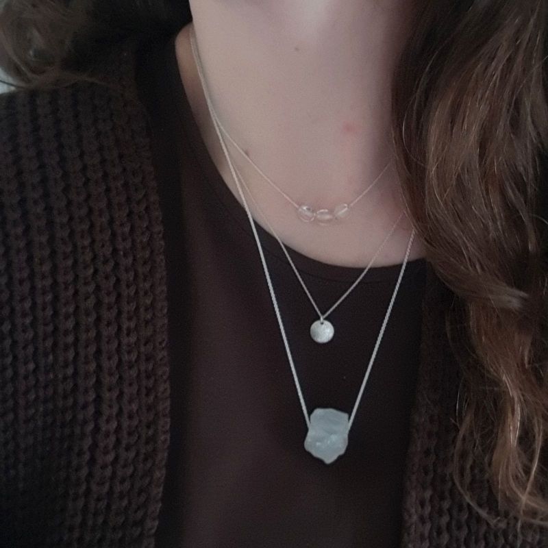 Silverhalsband Spirit Stone Bergkristall tillsammans med silverhalsband La Luna grace & silversmycke Tiny pebbles bergkristall på person.