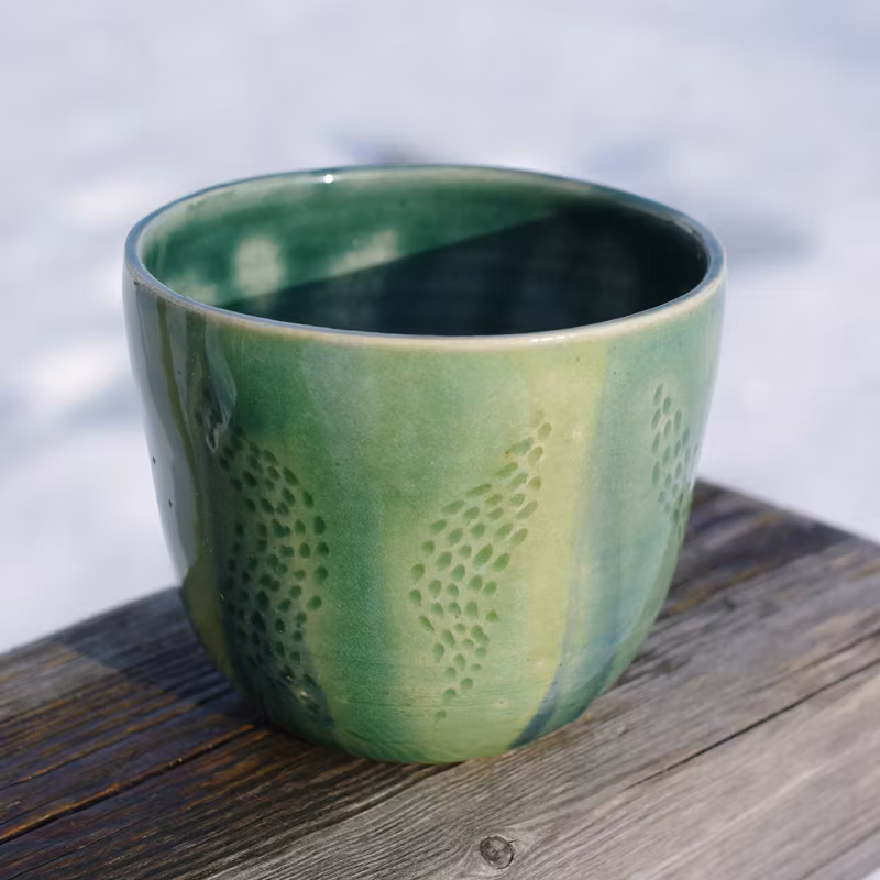 Grønn kaffekopp med tegning u/hank