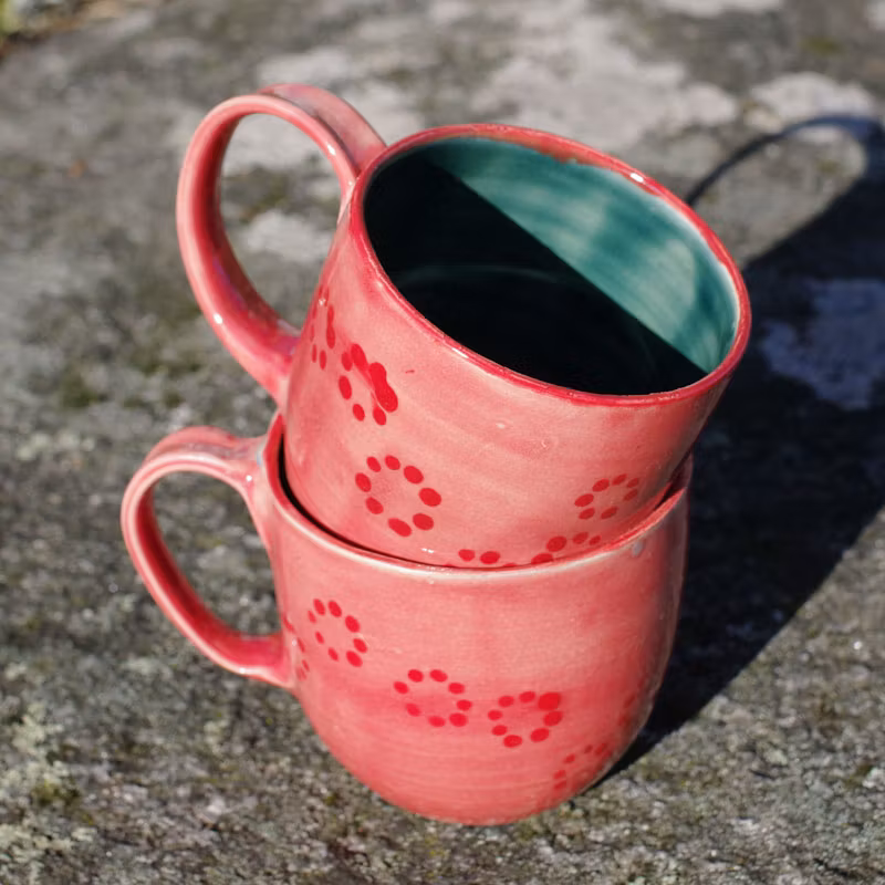 Rosa kaffekopp med røde prikker