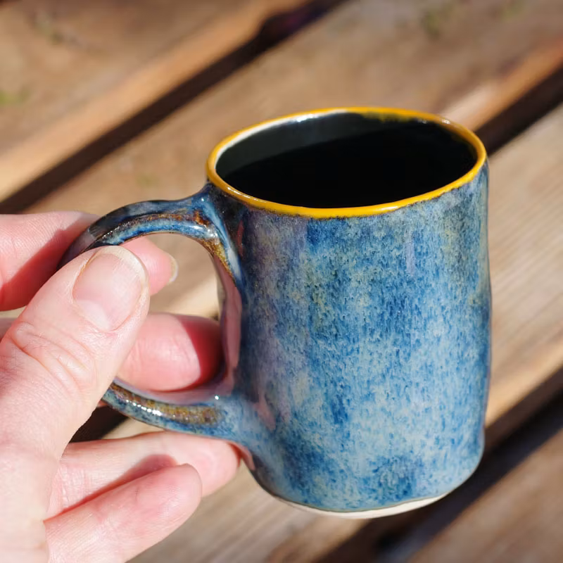 blå espressokopp med orange kant