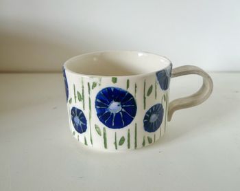 Låg kopp kavlat öra blå blomma