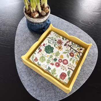 Gult kvadratiskt servettfat