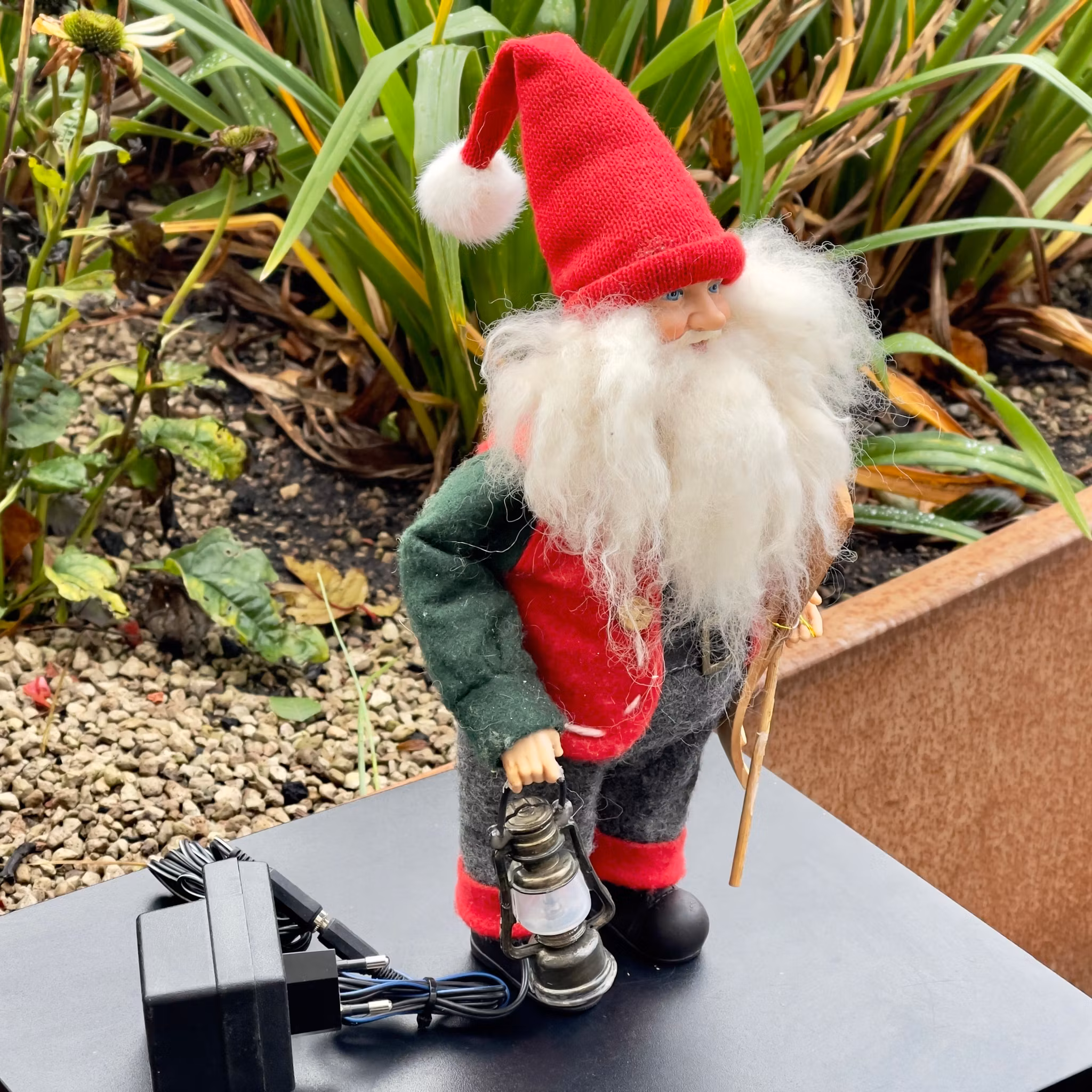 Père Noël âgé avec lanterne et skis