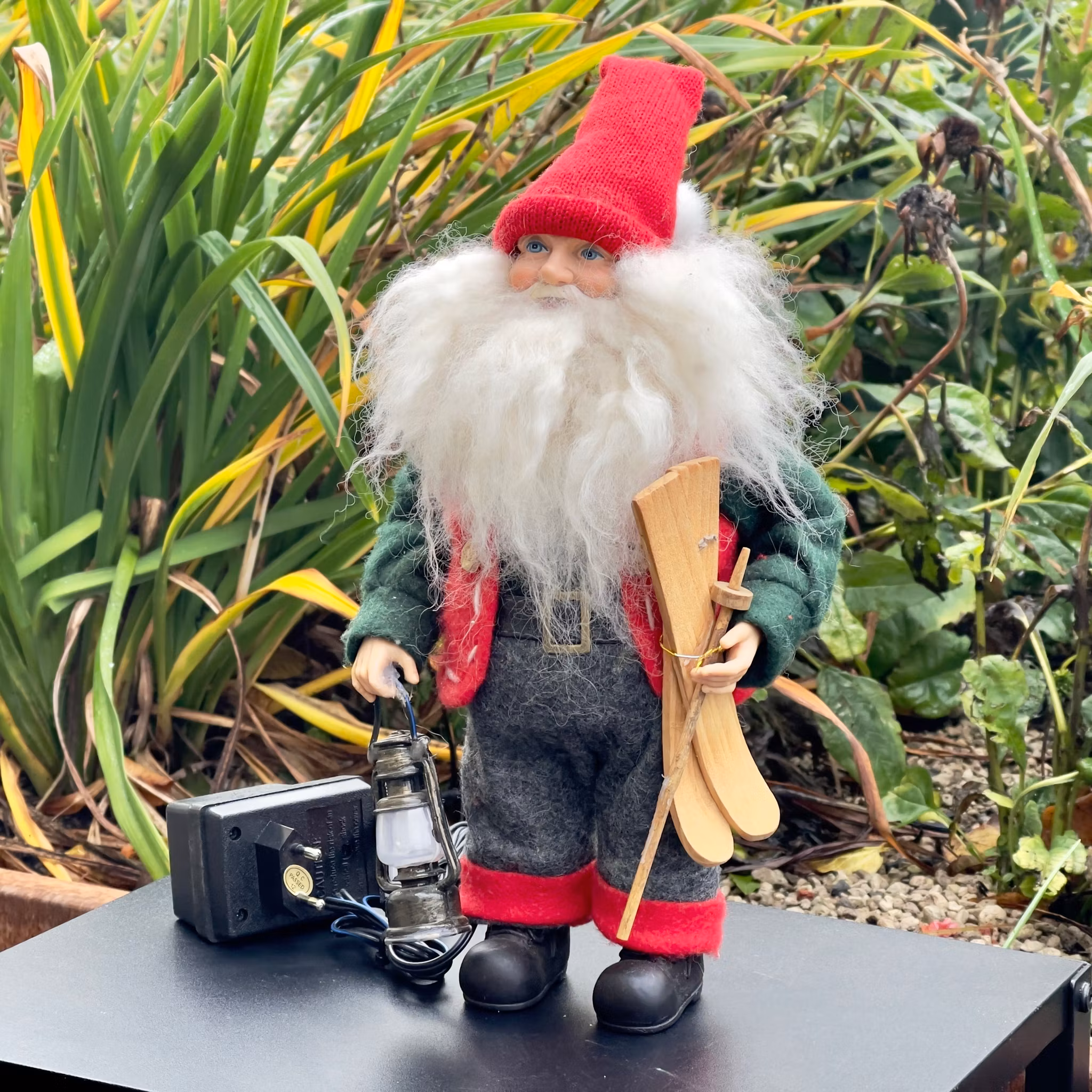 Père Noël âgé avec lanterne et skis