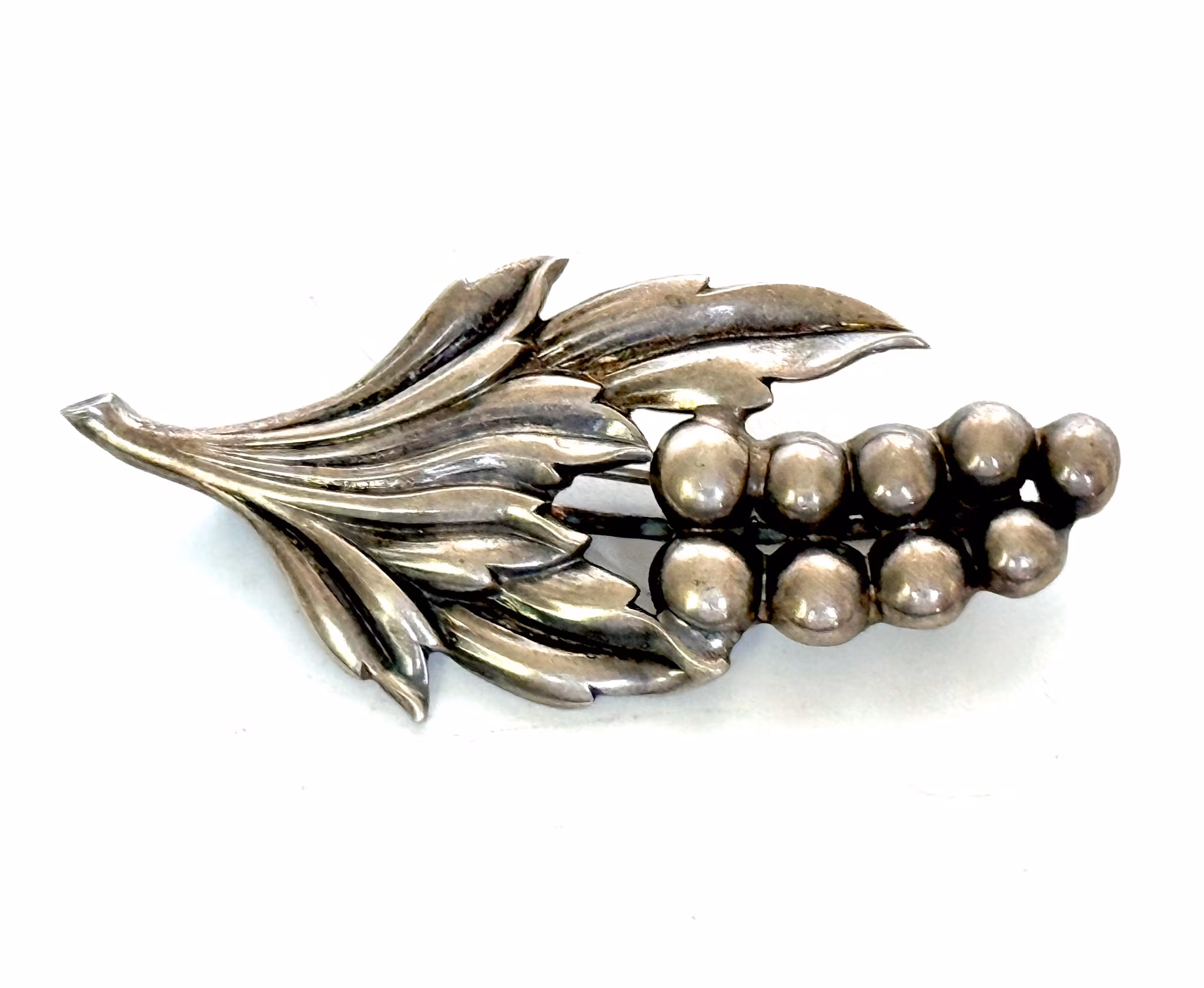 DG&Co hopeinen rintaneula orjanlaakerinlehdillä, 1951