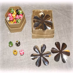 4 st små askar med olika pysselmaterial: berlocker, lås, pärlor och blommor- ca 90 delar