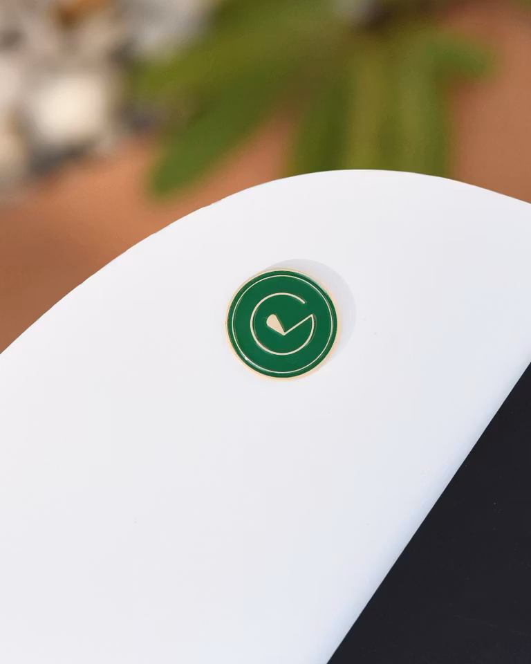 En golfbollsmarkör gjord i grön metall för att markera din boll på Green. Markören är designad efter Golfvantes gröna logotyp - GREEN LABEL