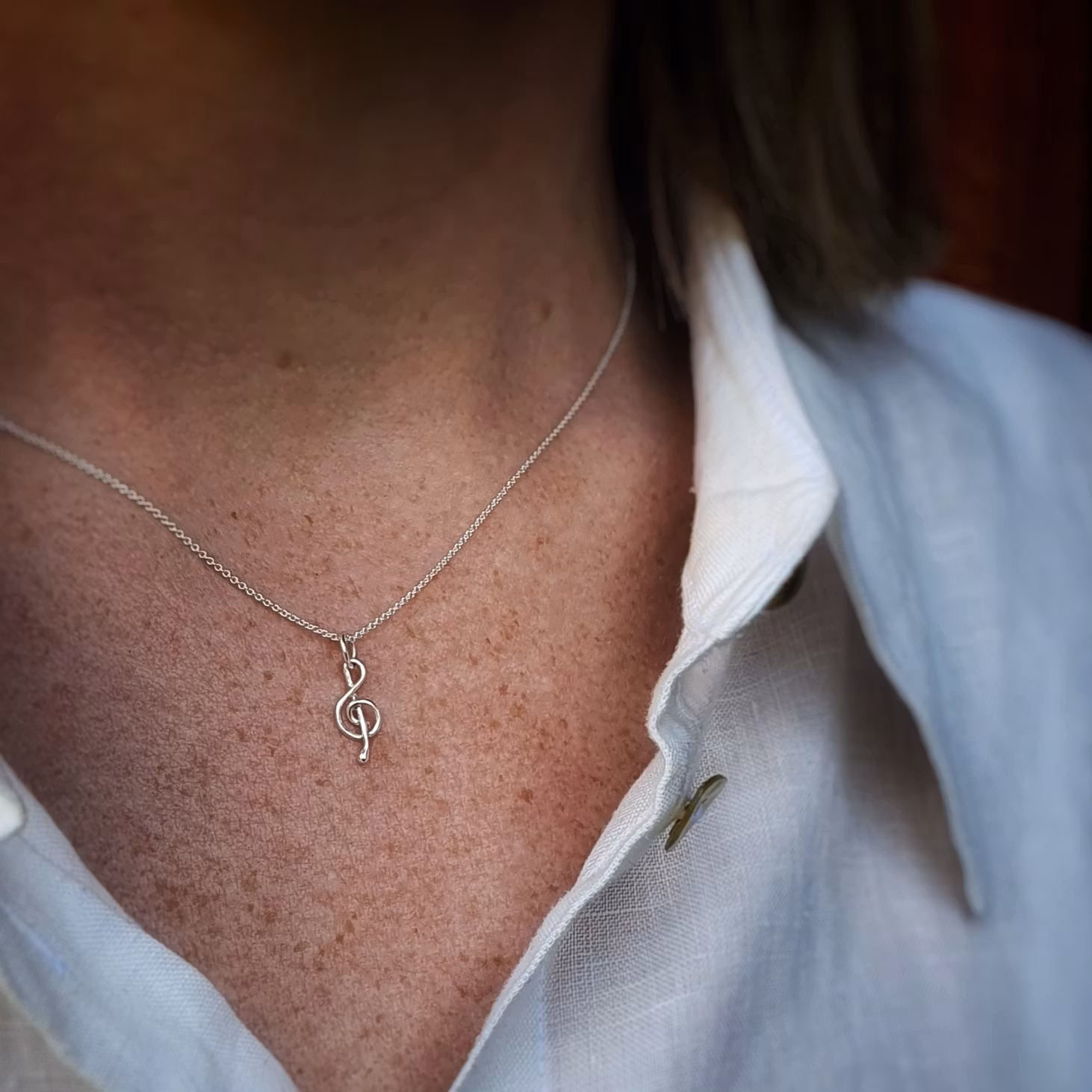 Silverhalsband g-klav i en ankarkedja.