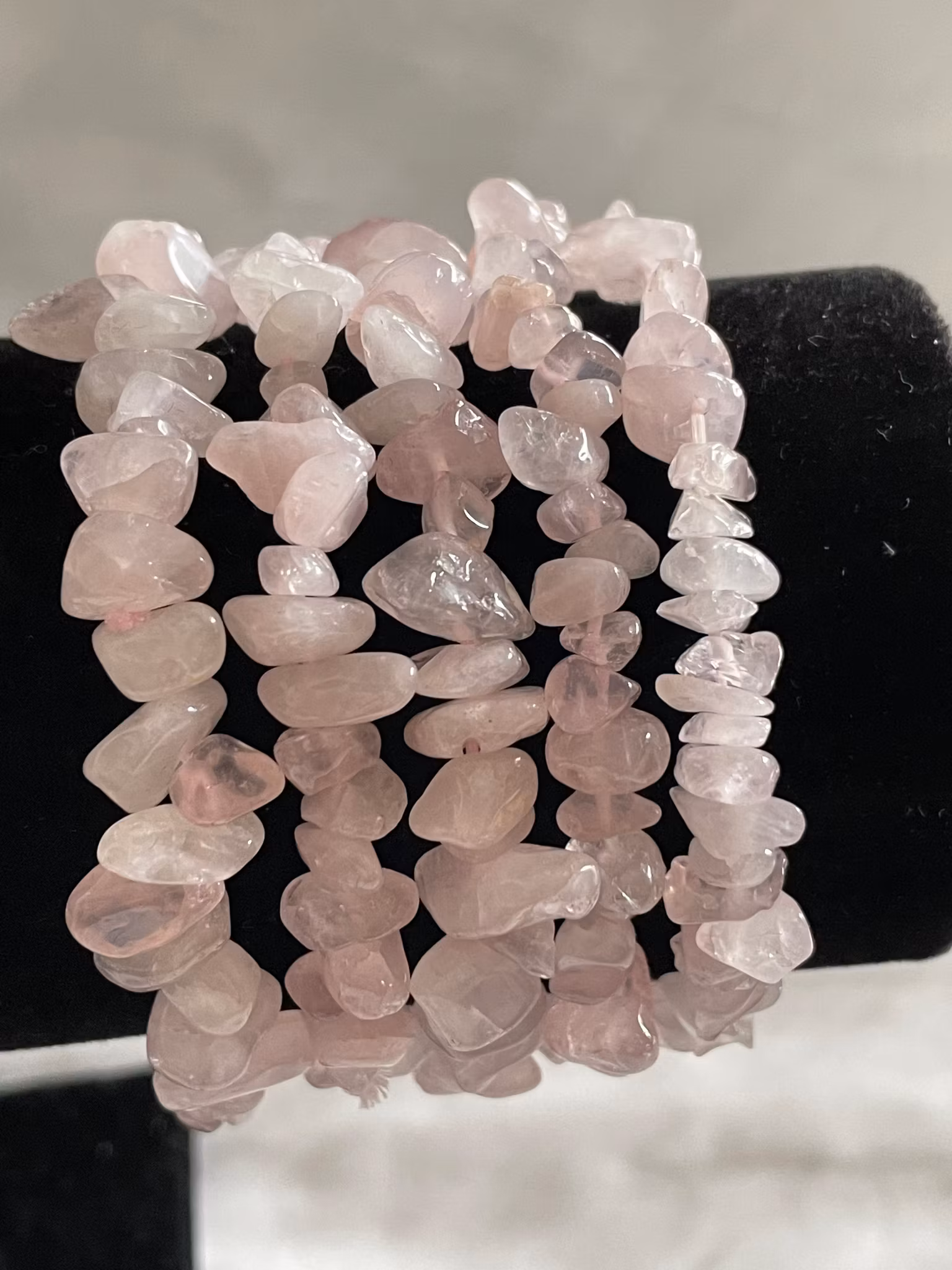 På bilden visas flera armband med små rosenkvartschips
