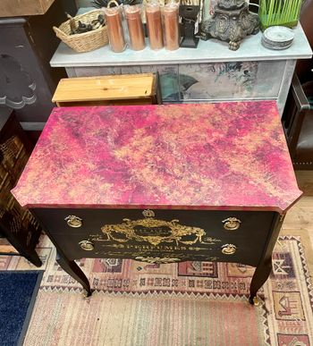 Svart byrå med rosa marmor.