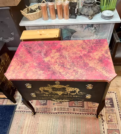 Svart byrå med rosa marmor.