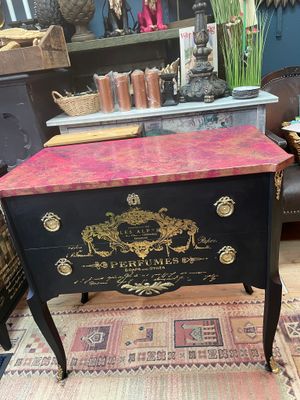 Svart byrå med rosa marmor.