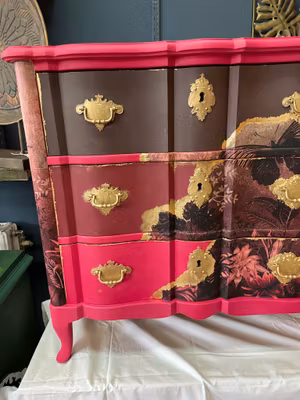 Byrå läckert målad i mörkrosa brunt och vinröd med detaljer i guld.