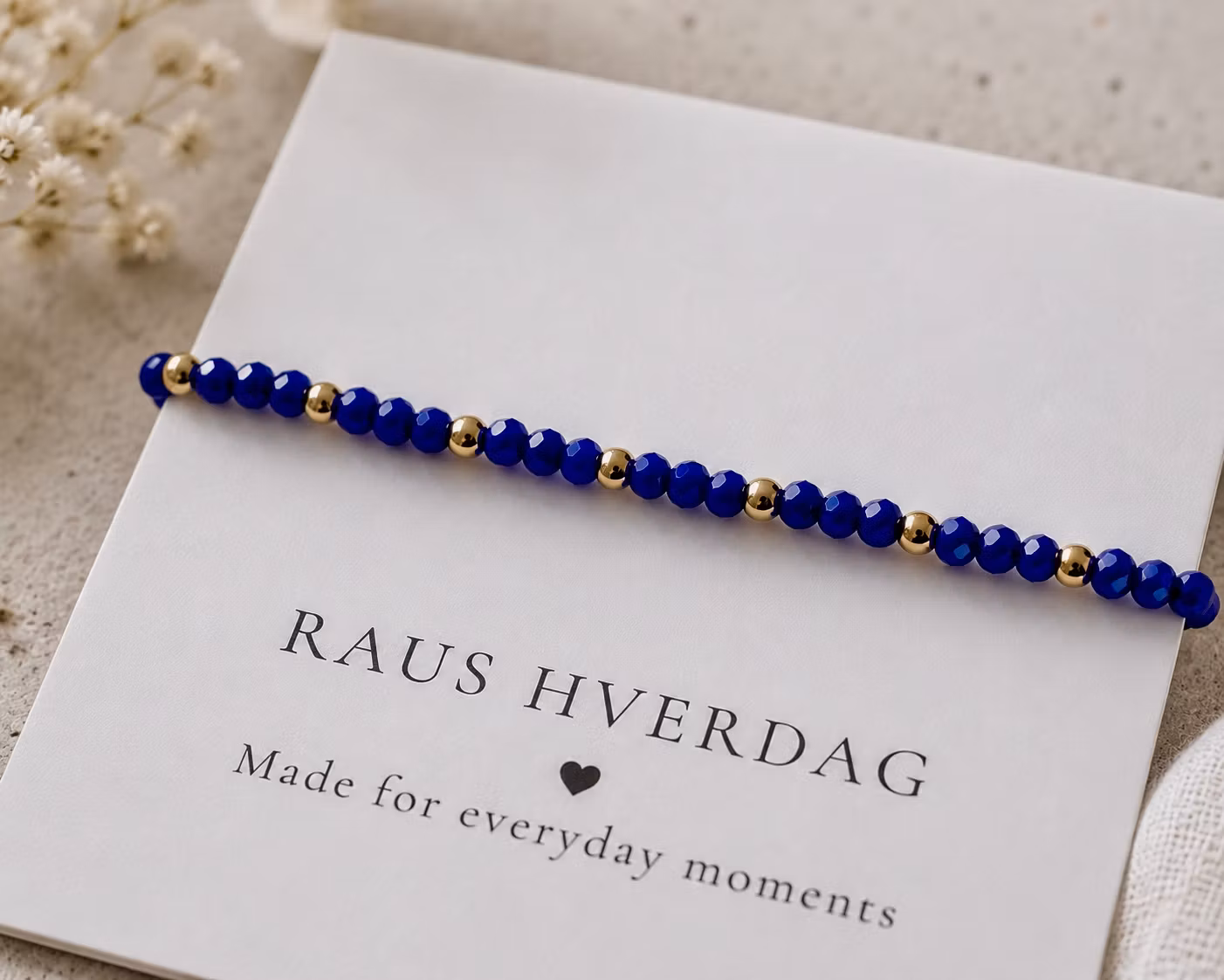 Armbånd med mørk blå perler & gulldetaljer