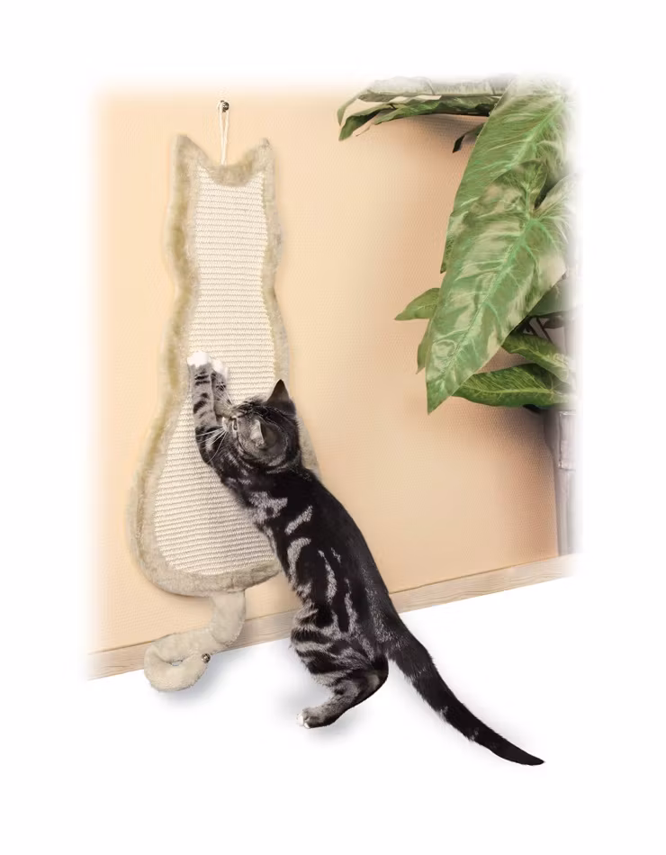 En kattformad klösbräda som är monterad på väggen. Här står en katt och vässar sina klor.