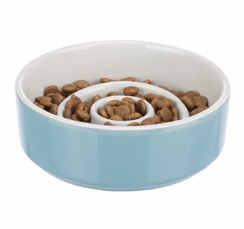 En blå slow feedskål i keramik, med mat inuti.