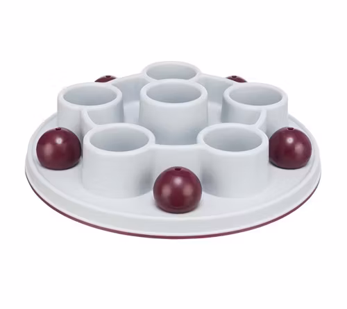 En grå rund kattleksak med flera öppningar med plats för kattgodis.