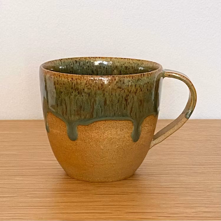 Kopp med rinnig grön glasyr