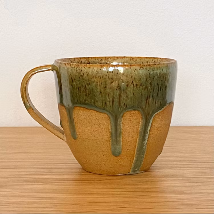 Kopp med rinnig grön glasyr