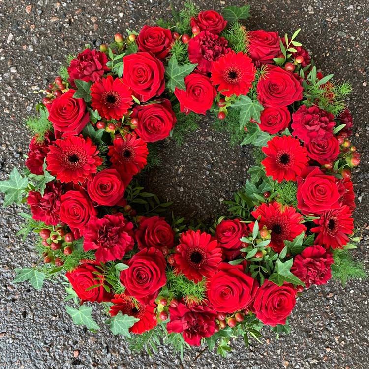 Krans med olika röda blommor, rosor mm. (Bilden 3500:-) ca 40 cm i diameter