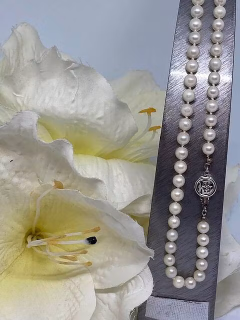 Vackert klassiskt saltvattenpärlcollier med knutar. Längd 42cm med ailverlås