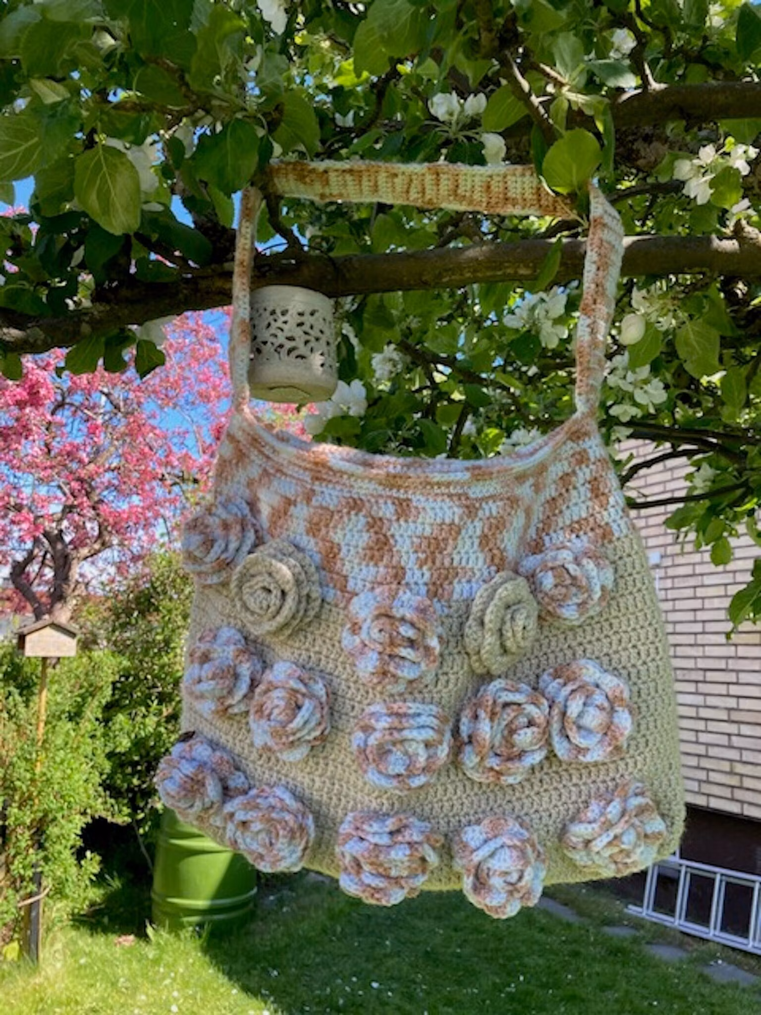 Virkad väska täckt med vackra virkade rosor på framsidan. Design Jemasmix hos Ericsson Ur och Guld