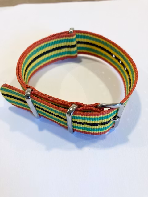 Textil-klockarmband fräckt randat i rött grönt gult och svart hos Ericsson Ur och Guld
