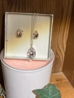 silverfärgat halsband och örhänge  meden droppformad ljuskristall