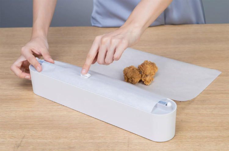 Plastic foil dispenser with sliding cutter
