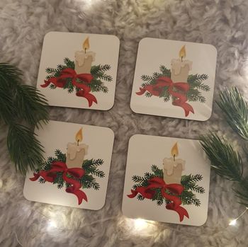 Glasunderlägg med ett ljus, grankvistar och en rosett.