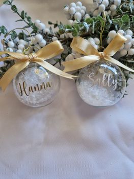 Transparent Julgranskula med namn, snö och rosett