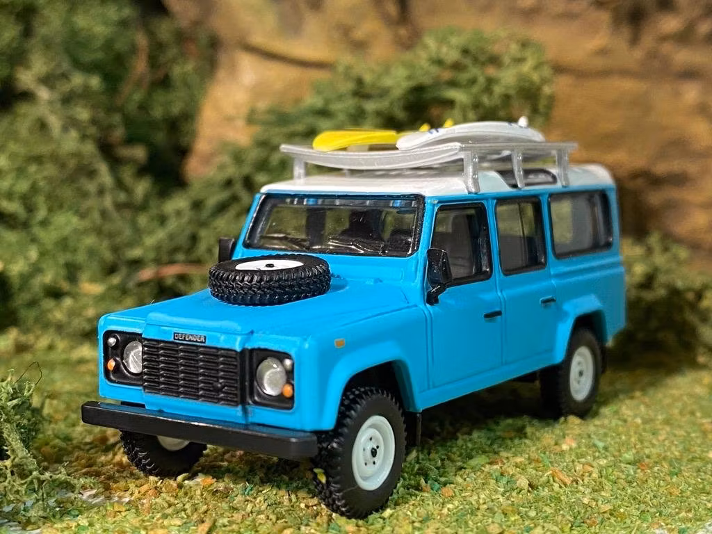 Skala 1/64 Land Rover Defender 110, Ljusblå m räcke & Surfingbräda från MINI GT