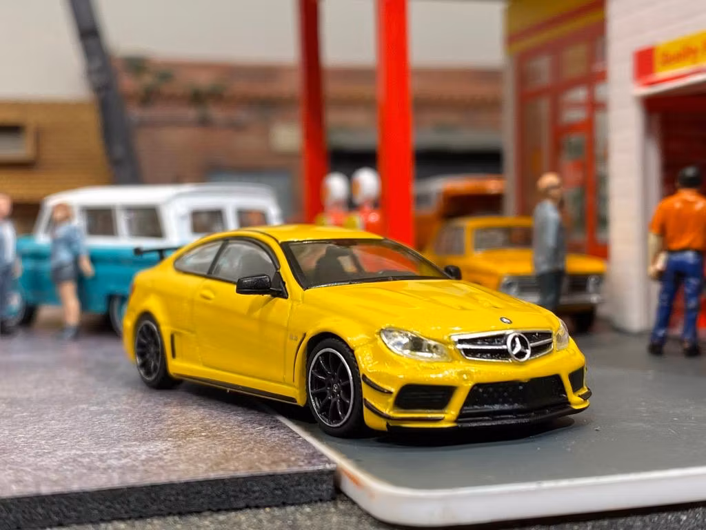 Skala 1/64 Mercedes-Benz C63 AMG Coupé Black series Gul f TARMAC works