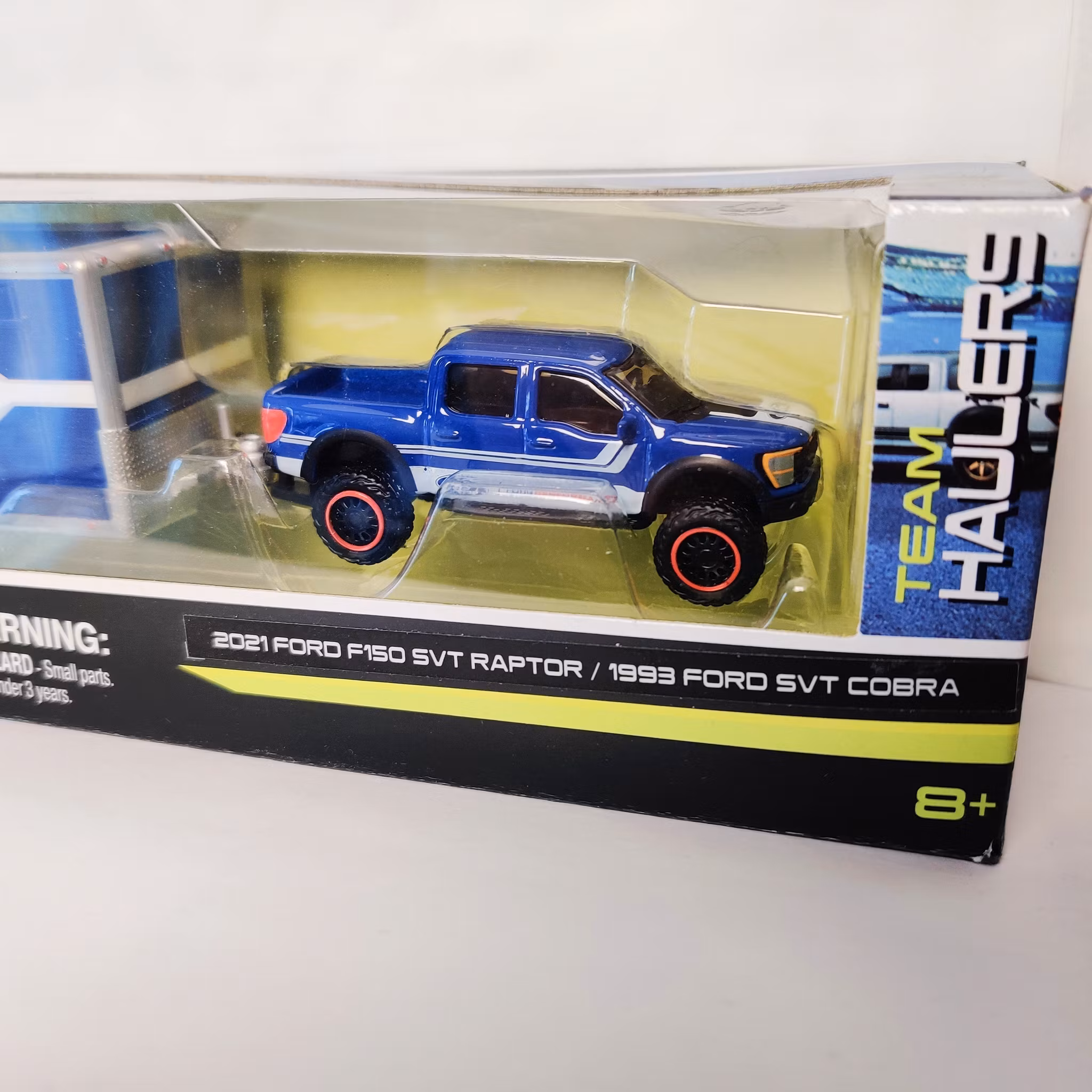 Skala 1/64 Maisto Design 21' Ford F150 SVT Raptor, 93' Ford SVT Cobra, bil/cartrailer